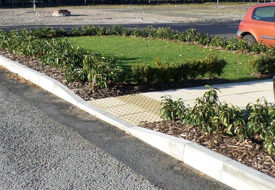 A commercial frontage with a new shrub bed, kerbing and gravel mulch beside the road